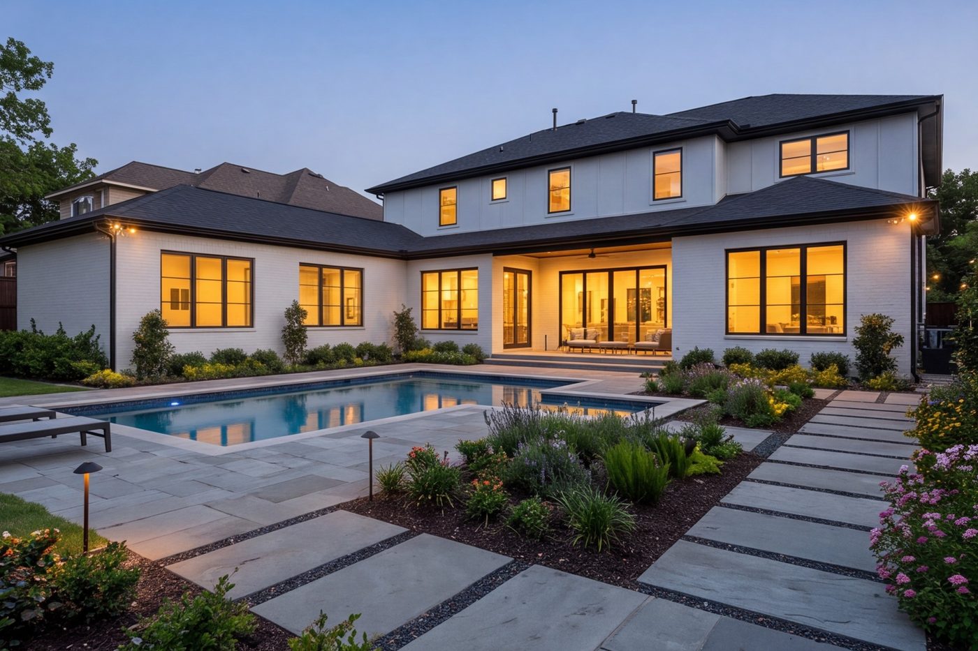 Back yard with stone patio, pool and planted beds, house in view